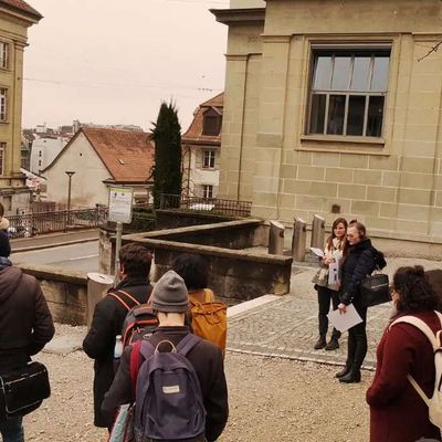 Un public écoute une guide dans la ville de Lausanne
